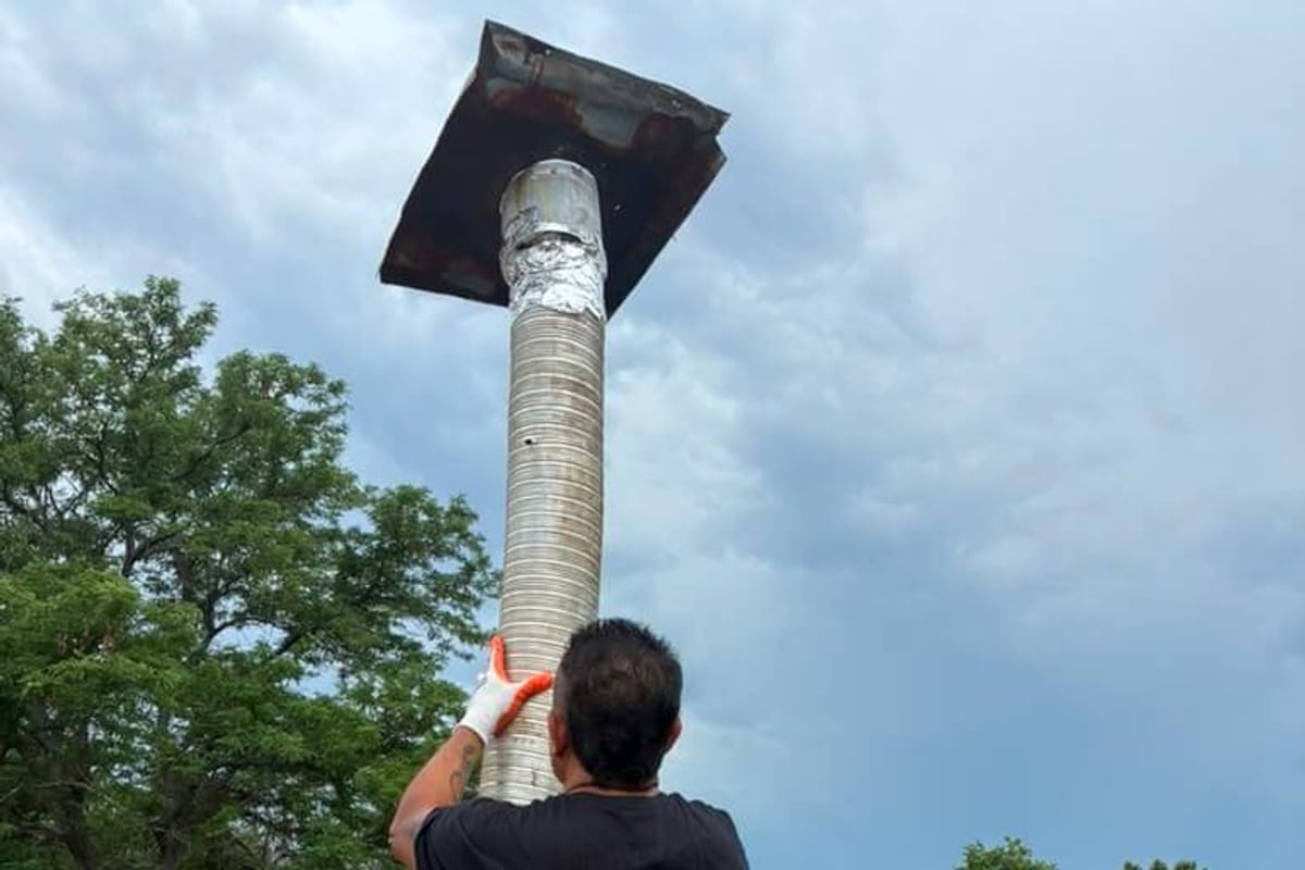 A flue pipe and its scorched top plate raised clear of a Boulder chimney during a reline